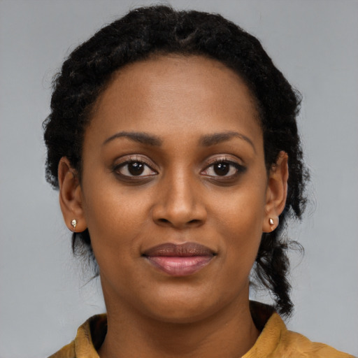 Joyful black young-adult female with long  brown hair and brown eyes