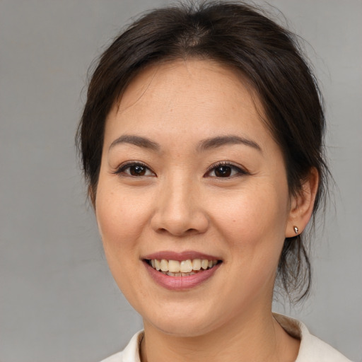 Joyful asian young-adult female with medium  brown hair and brown eyes