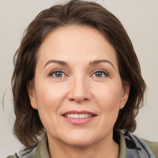 Joyful white adult female with medium  brown hair and grey eyes