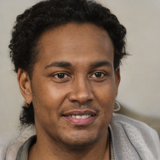 Joyful black adult male with short  brown hair and brown eyes