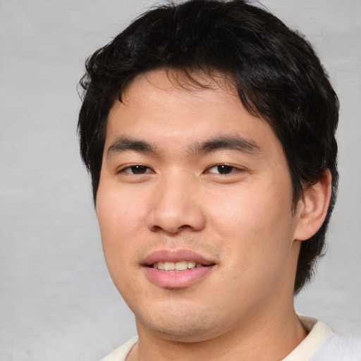 Joyful asian young-adult male with short  brown hair and brown eyes