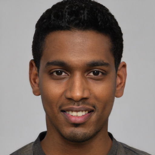 Joyful black young-adult male with short  black hair and brown eyes