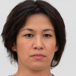 Joyful asian adult female with medium  brown hair and brown eyes