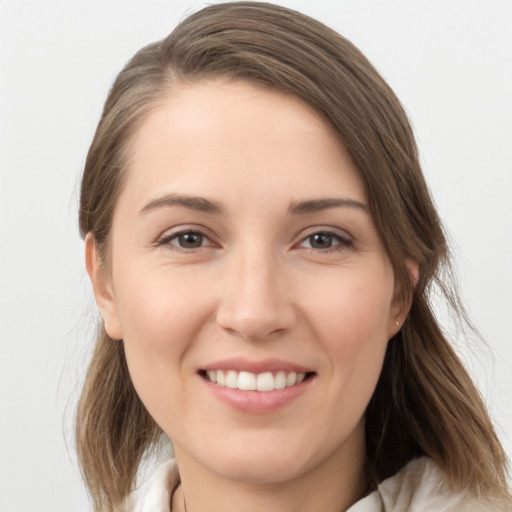 Joyful white young-adult female with medium  brown hair and grey eyes