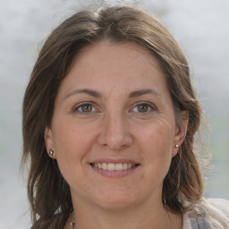 Joyful white adult female with medium  brown hair and grey eyes