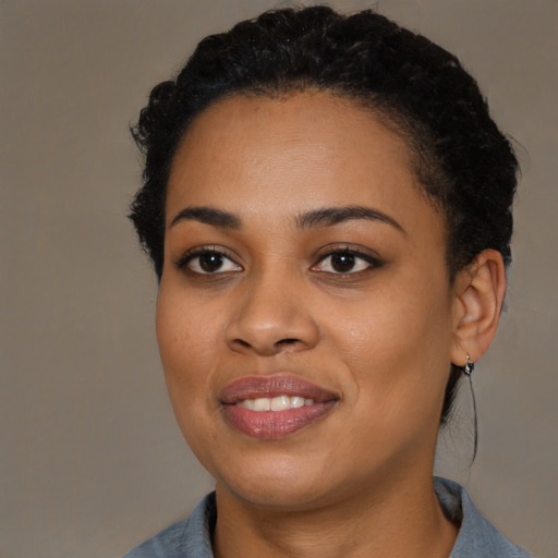 Joyful black young-adult female with short  black hair and brown eyes