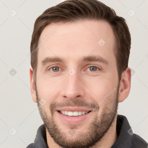 Joyful white young-adult male with short  brown hair and grey eyes