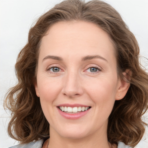 Joyful white young-adult female with medium  brown hair and blue eyes