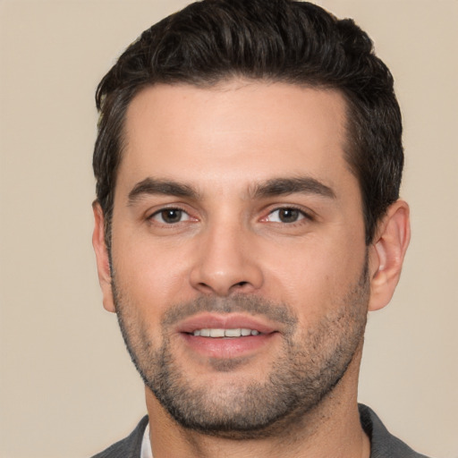 Joyful white young-adult male with short  black hair and brown eyes