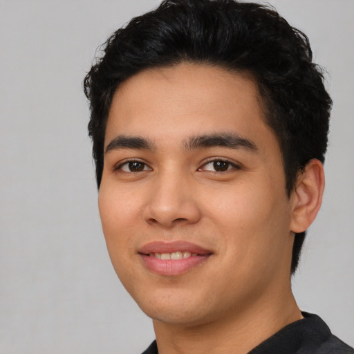 Joyful latino young-adult male with short  black hair and brown eyes