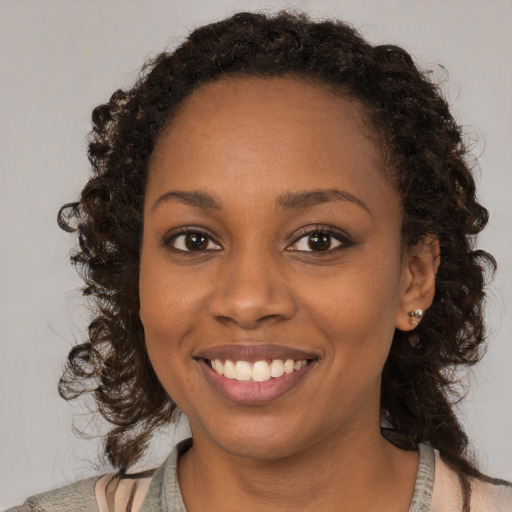 Joyful black young-adult female with medium  brown hair and brown eyes