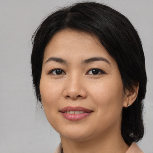 Joyful asian young-adult female with medium  brown hair and brown eyes