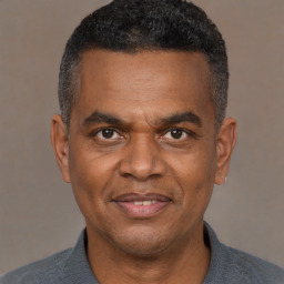 Joyful black adult male with short  black hair and brown eyes