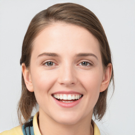 Joyful white young-adult female with medium  brown hair and blue eyes