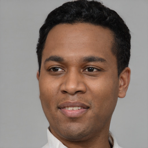 Joyful black young-adult male with short  black hair and brown eyes