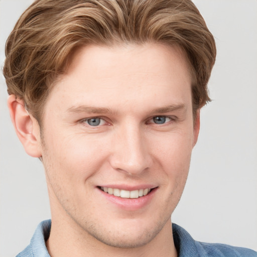 Joyful white young-adult male with short  brown hair and blue eyes