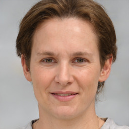 Joyful white adult female with medium  brown hair and grey eyes