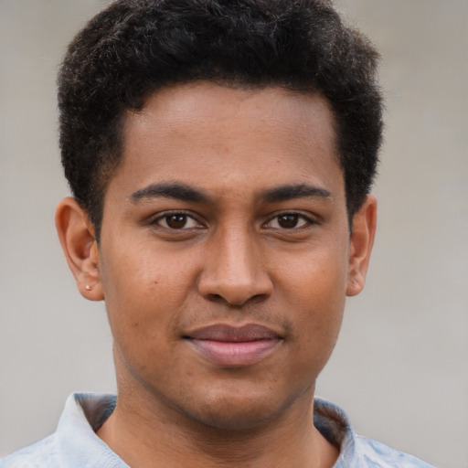 Joyful black young-adult male with short  brown hair and brown eyes