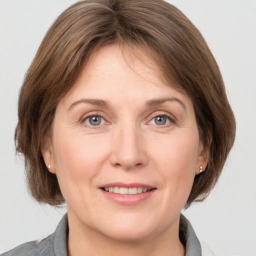 Joyful white adult female with medium  brown hair and grey eyes