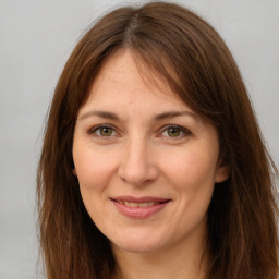 Joyful white adult female with long  brown hair and brown eyes