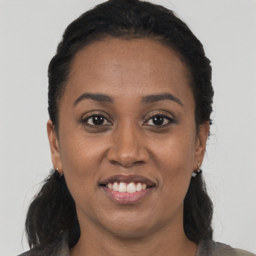 Joyful black adult female with long  black hair and brown eyes