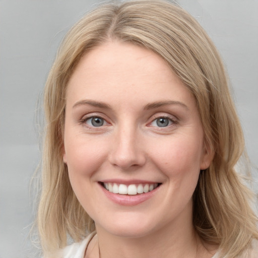 Joyful white young-adult female with medium  brown hair and blue eyes