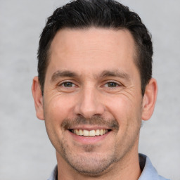 Joyful white adult male with short  brown hair and brown eyes