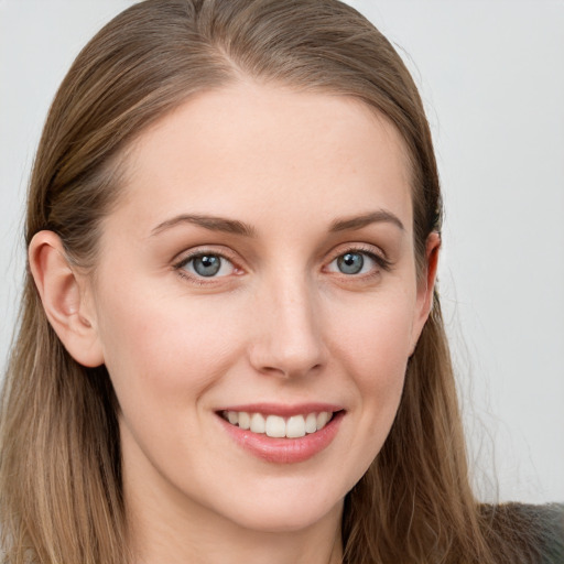 Joyful white young-adult female with long  brown hair and blue eyes