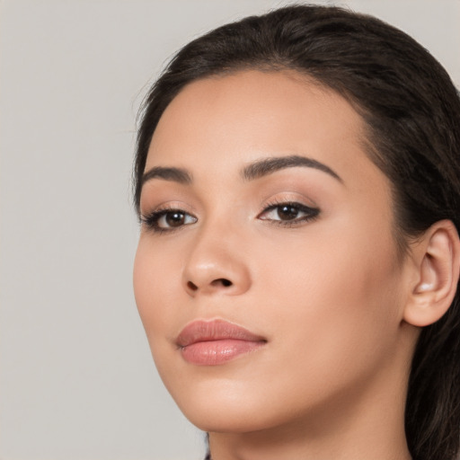 Joyful latino young-adult female with long  black hair and brown eyes