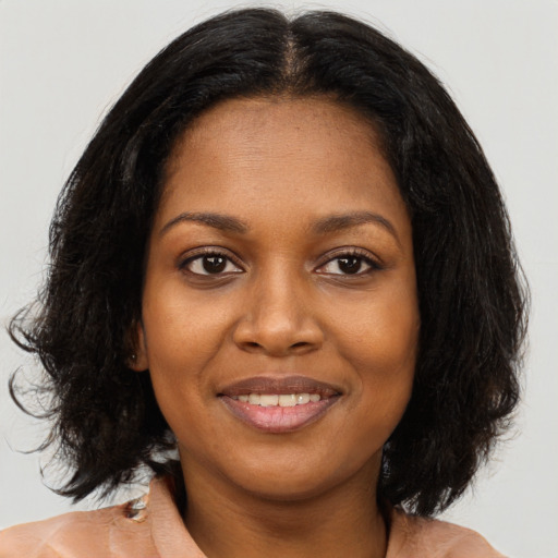 Joyful black young-adult female with medium  brown hair and brown eyes