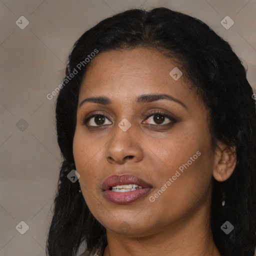 Joyful black young-adult female with long  black hair and brown eyes