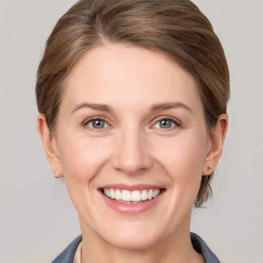 Joyful white young-adult female with short  brown hair and grey eyes