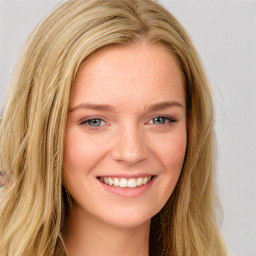 Joyful white young-adult female with long  brown hair and blue eyes