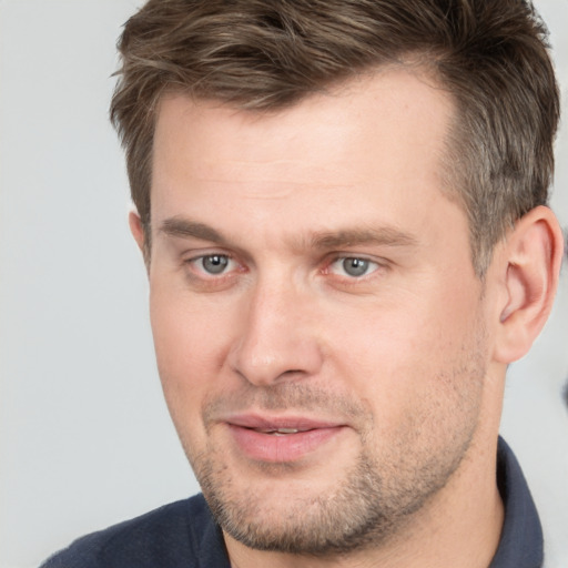 Joyful white adult male with short  brown hair and grey eyes