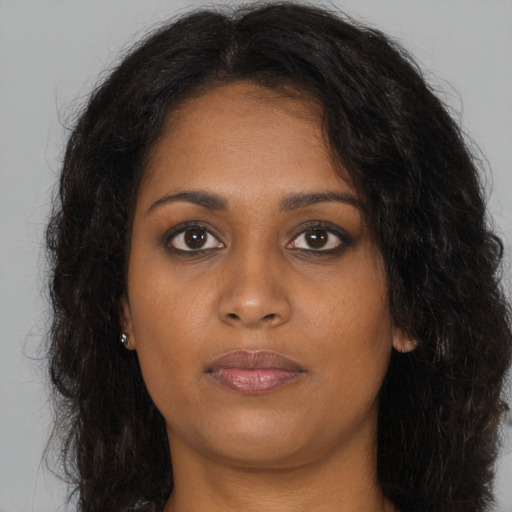 Joyful black young-adult female with long  brown hair and brown eyes