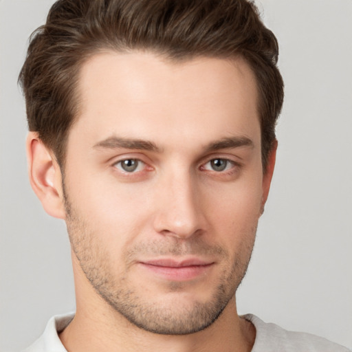 Joyful white young-adult male with short  brown hair and grey eyes