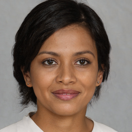 Joyful black young-adult female with medium  brown hair and brown eyes