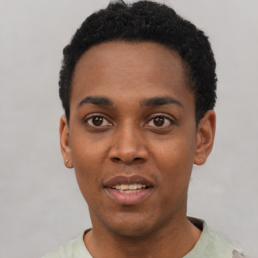Joyful black young-adult male with short  black hair and brown eyes