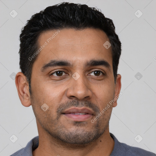 Joyful latino young-adult male with short  black hair and brown eyes