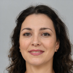 Joyful white adult female with long  brown hair and brown eyes