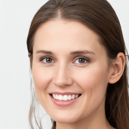 Joyful white young-adult female with long  brown hair and grey eyes