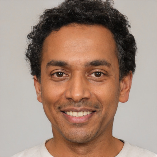 Joyful latino adult male with short  black hair and brown eyes