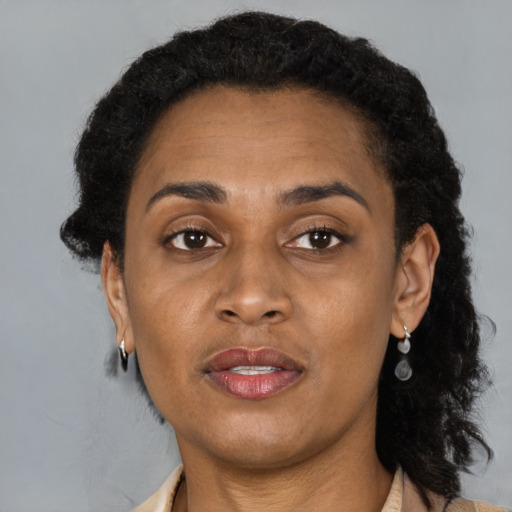 Joyful black adult female with short  brown hair and brown eyes