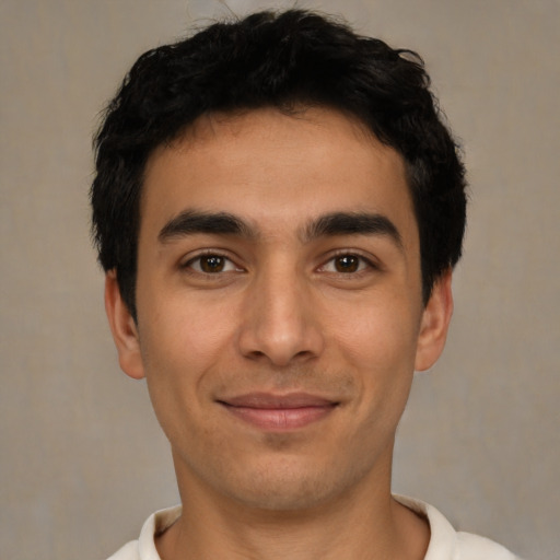 Joyful latino young-adult male with short  black hair and brown eyes