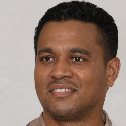 Joyful black young-adult male with short  black hair and brown eyes