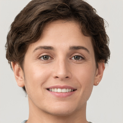 Joyful white young-adult female with short  brown hair and grey eyes