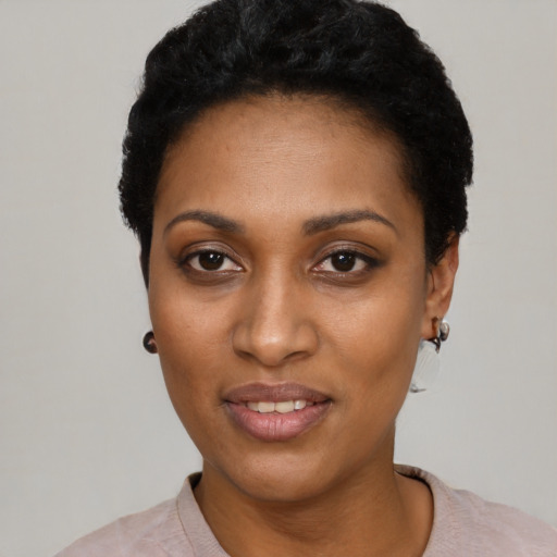 Joyful black young-adult female with short  black hair and brown eyes