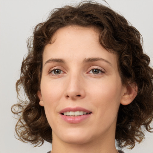 Joyful white young-adult female with medium  brown hair and green eyes