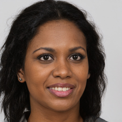 Joyful black young-adult female with long  brown hair and brown eyes