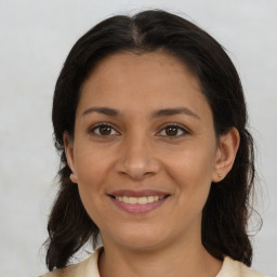 Joyful latino young-adult female with medium  brown hair and brown eyes